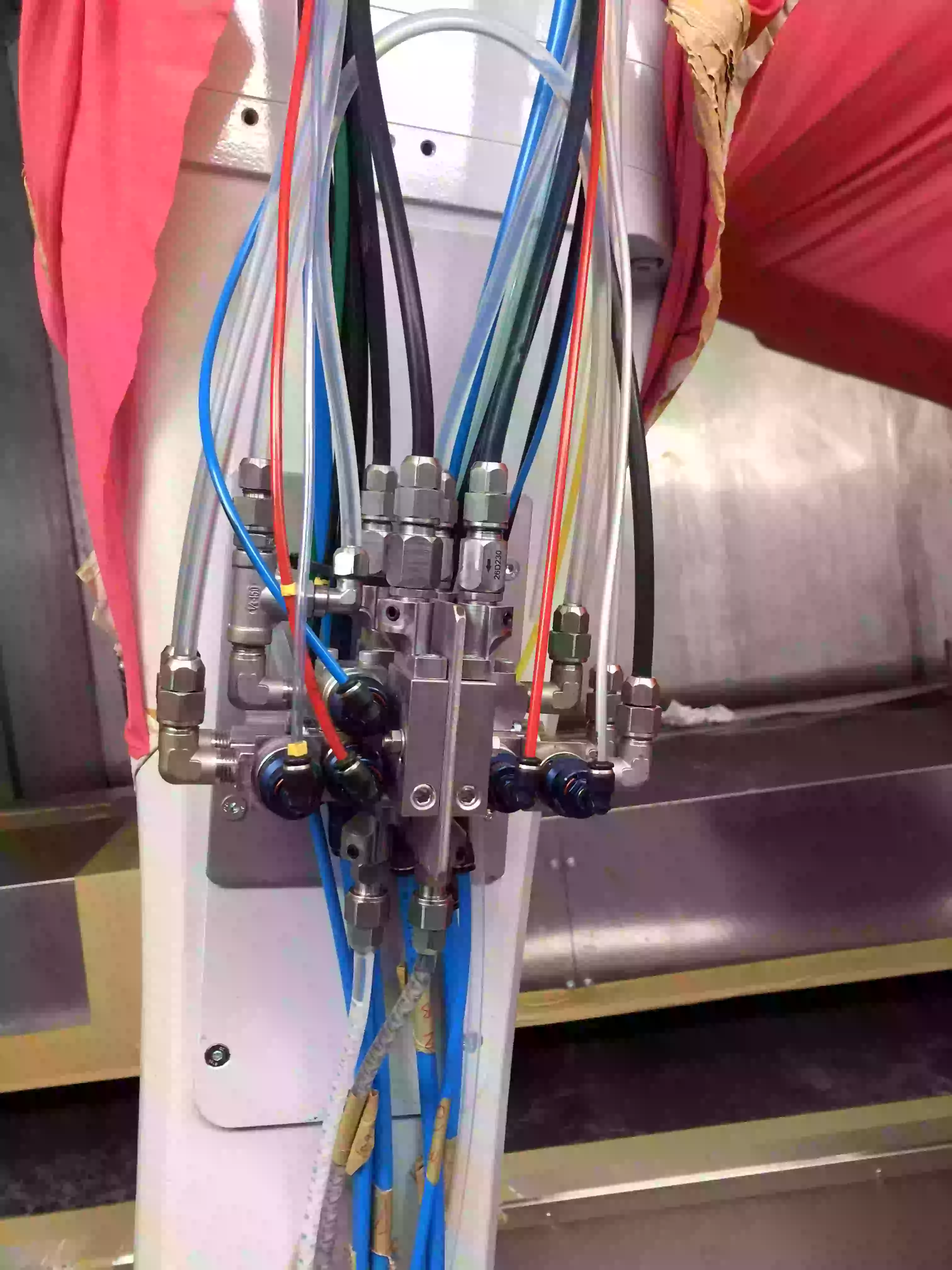 Bloque de mezcla con purgas independientes, compacto, con válvulas de entrada y salida, diseñado para mezclar con precisión diferentes componentes de pintura en sistemas automatizados.